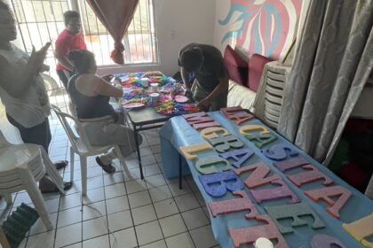 People crafting colorful letters at a table.