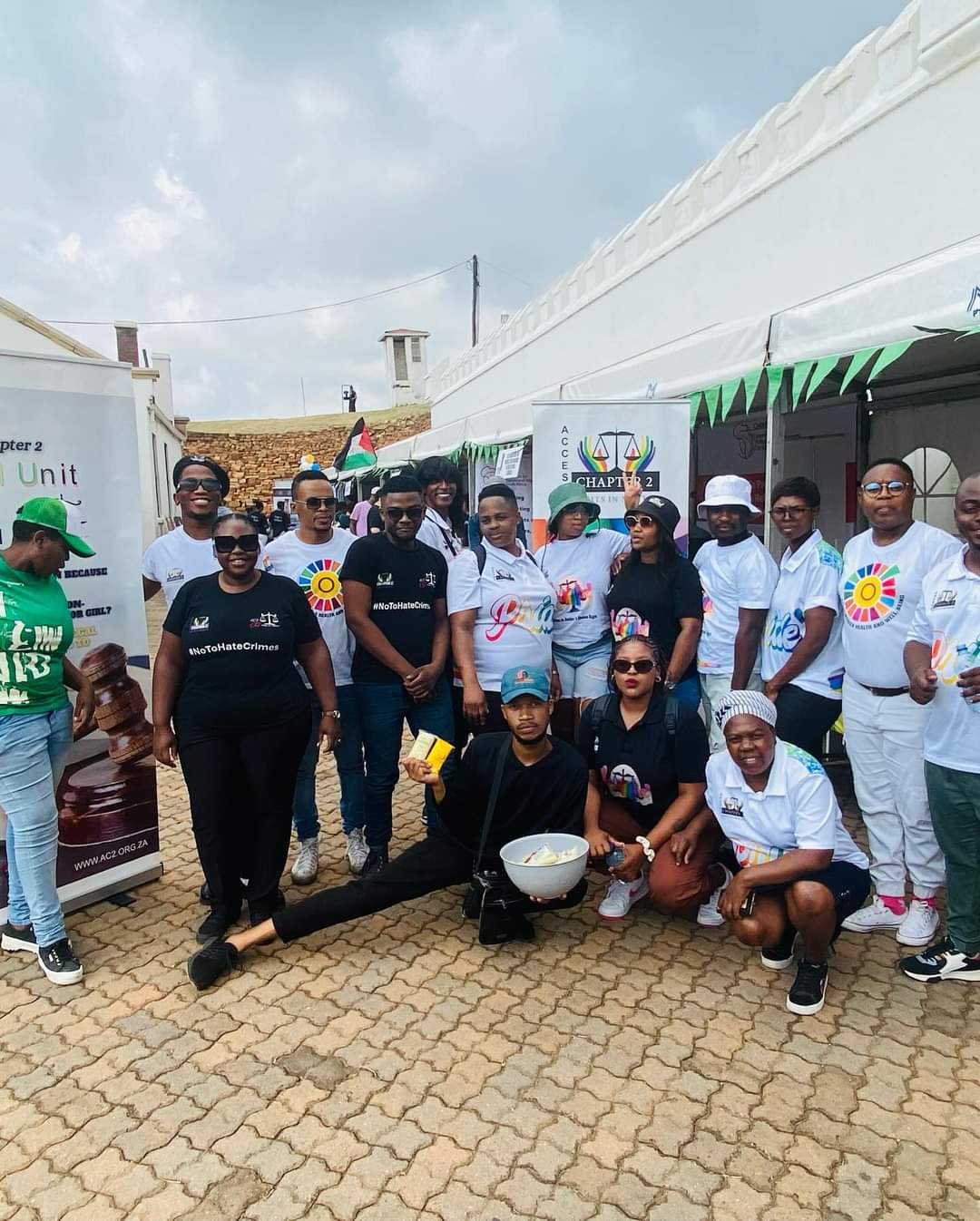 Group of people posing at an outdoor event with banners.