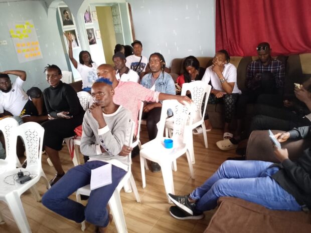 Indoor session with participants seated on chairs.