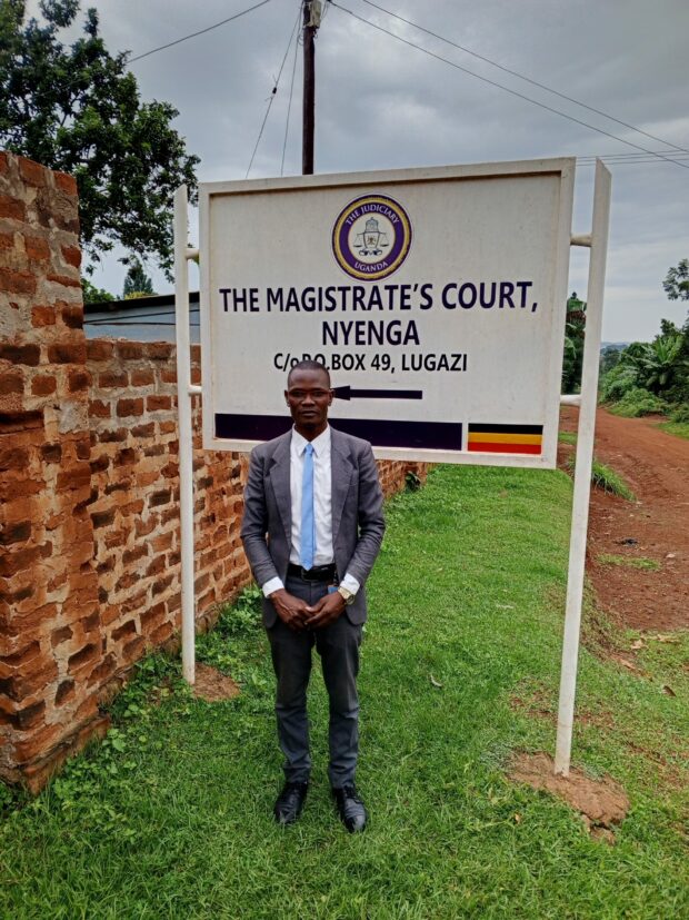 Person in a suit standing in front of a Magistrate’s Court sign.