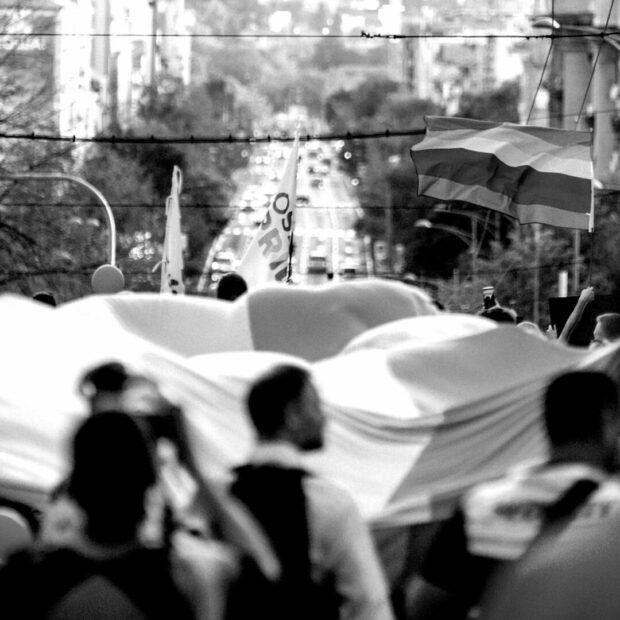 Crowd carrying a large banner.