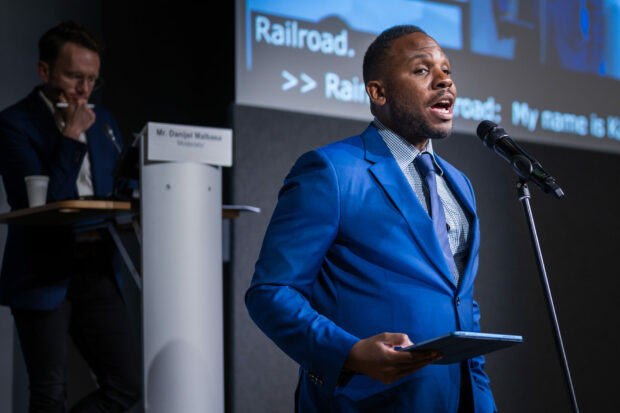 Person in blue suit speaking at a podium.